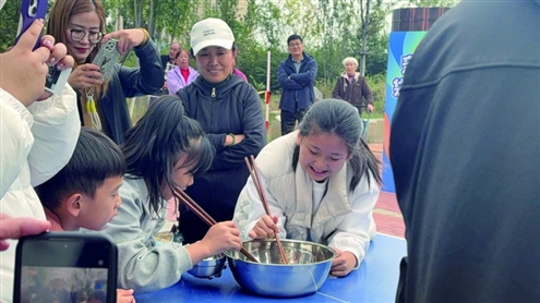 选手们手持竹筷反复调整角度夹取弹珠